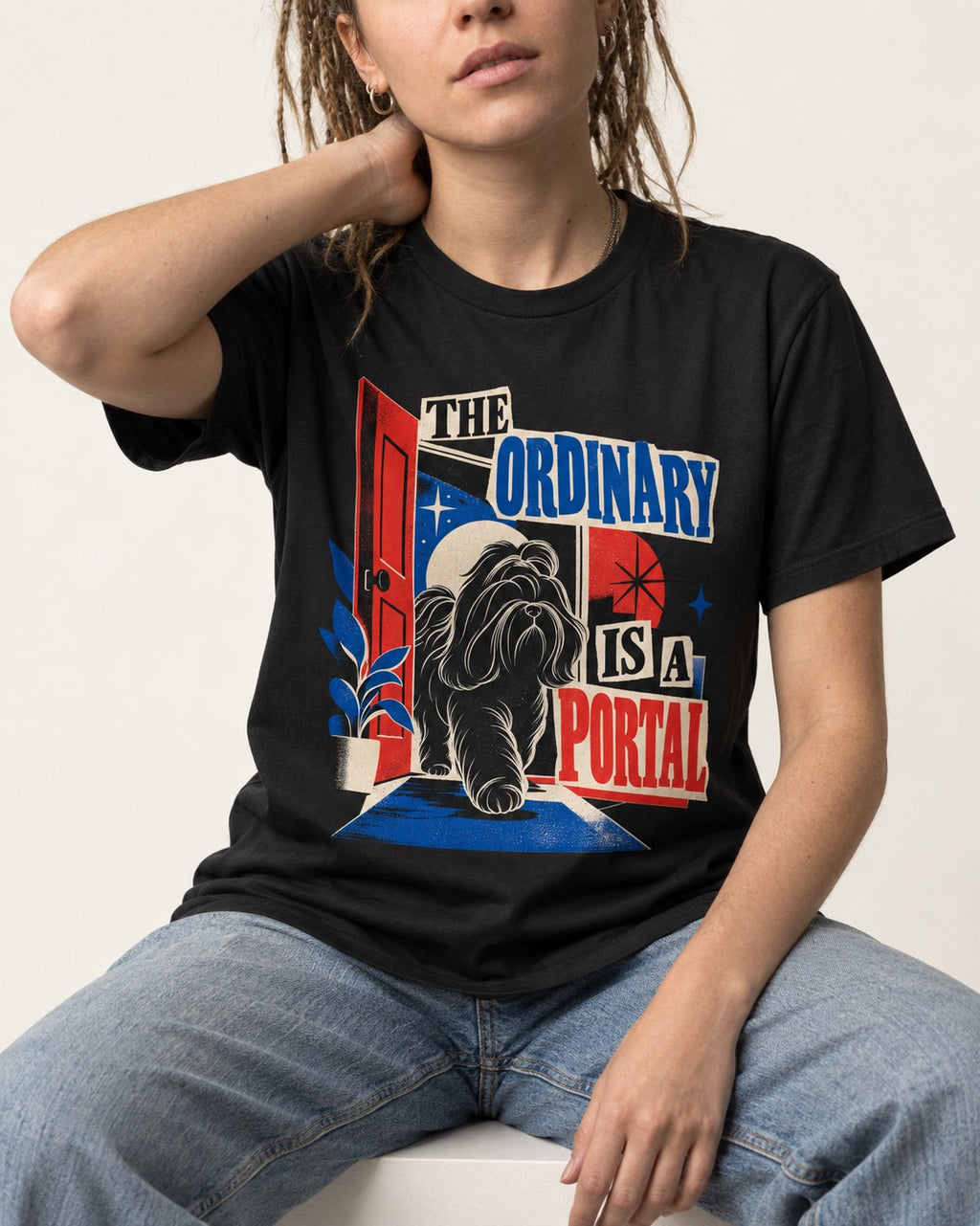 Shih Tzu The Ordinary Is a Portal Door Graphic T-Shirt in Black, worn by a seated model