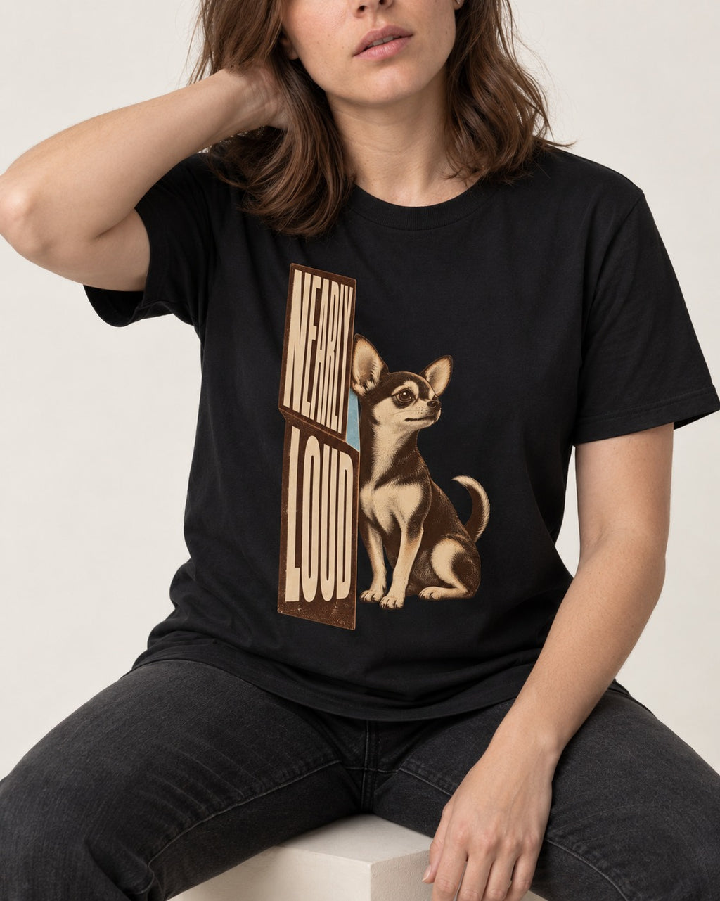 Chihuahua Never Loud T-Shirt in Black, worn by a seated model