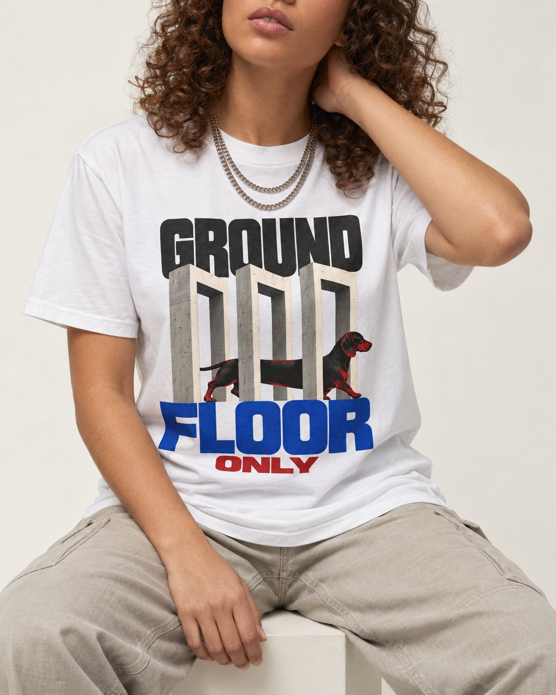 Ground Floor Only Dachshund T-Shirt in White, worn by a seated model