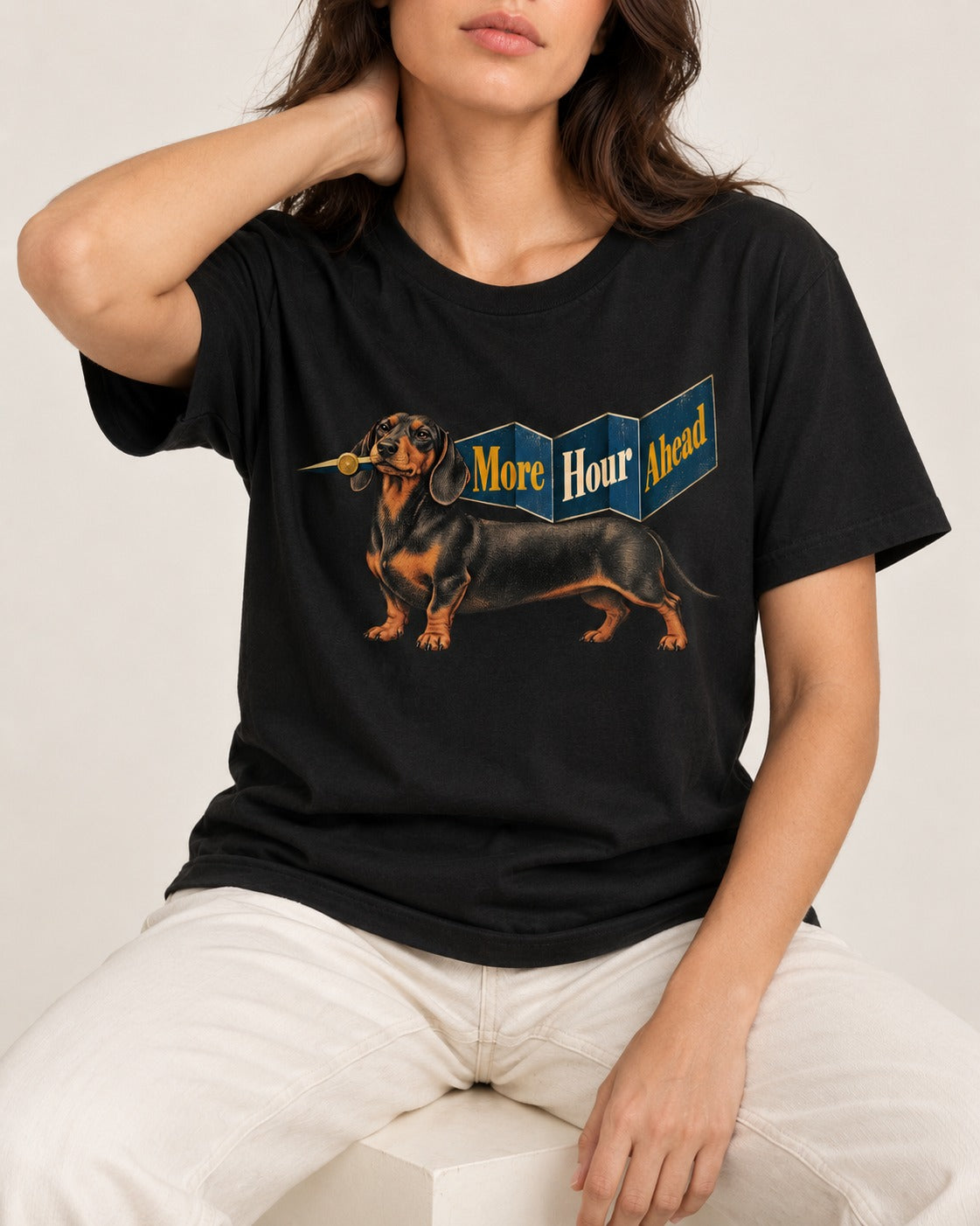 Dachshund More Hour Ahead Foldout Banner Graphic T-Shirt in Black, worn by a seated model