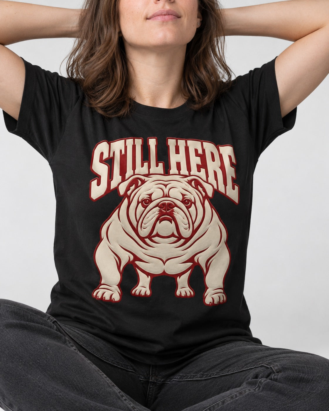 English Bulldog Still Here Collegiate Graphic T-Shirt in Black, worn by a seated model