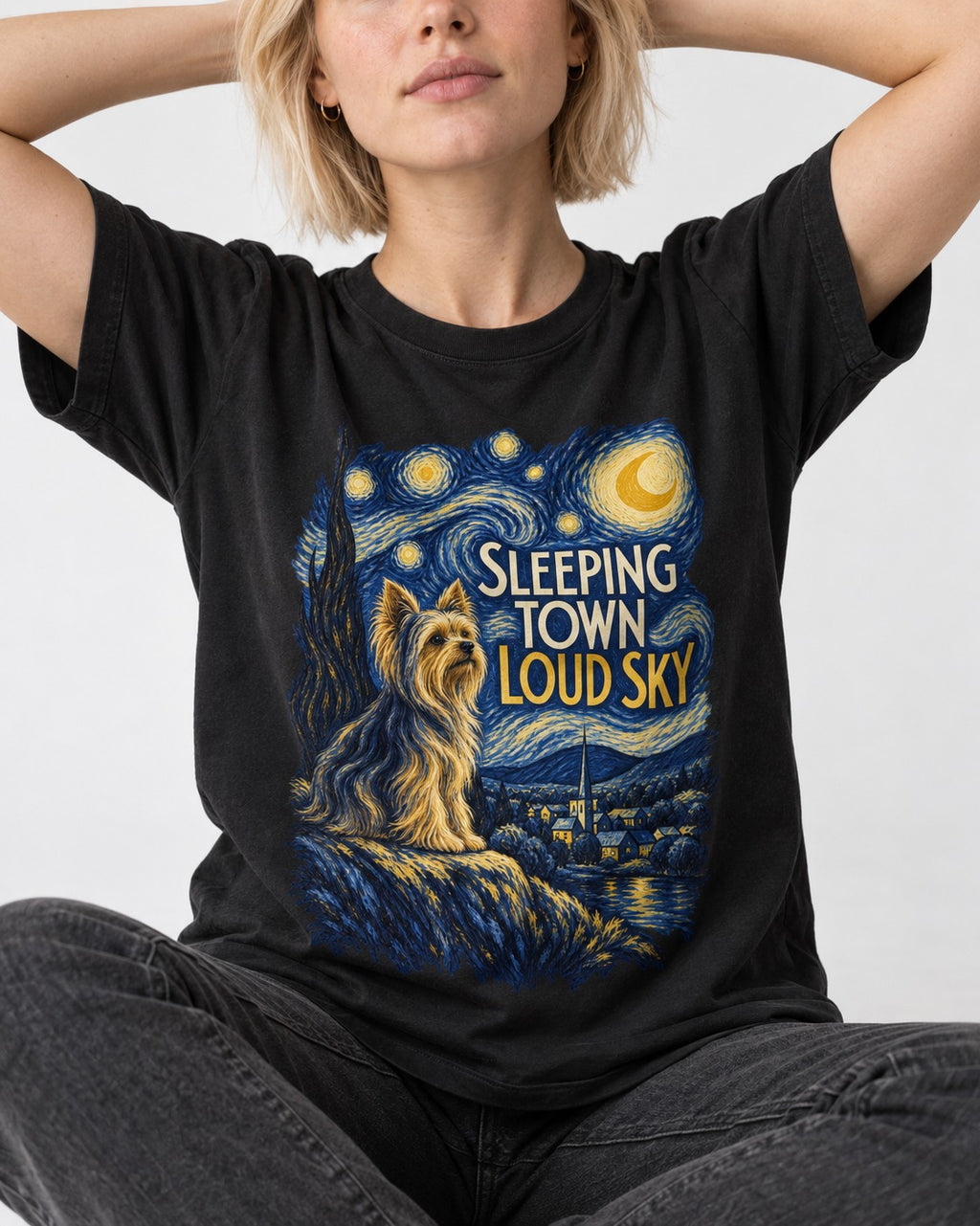 Yorkshire Terrier Sleeping Town Loud Sky Starry Night Graphic T-Shirt in Black, worn by a seated model