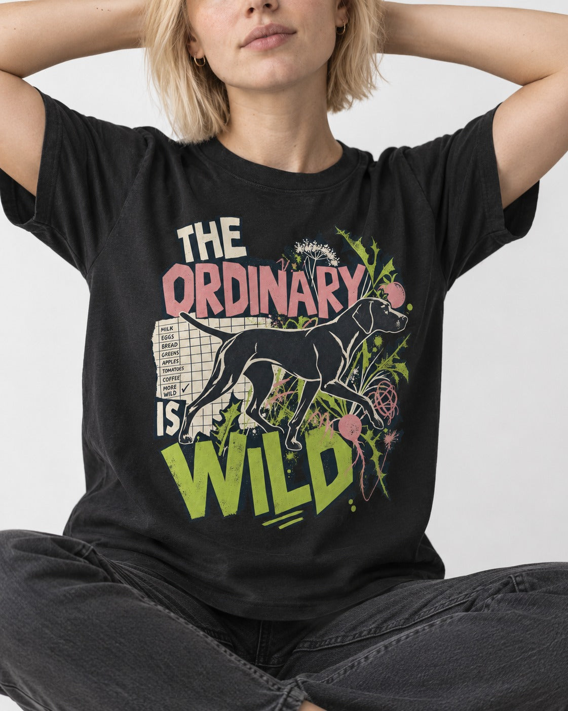 German Shorthaired Pointer The Ordinary Is Wild Grocery List Graphic T-Shirt in Black, worn by a seated model