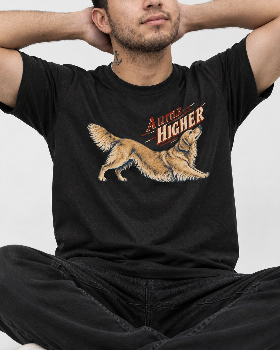 Golden Retriever A Little Higher Play Bow Graphic T-Shirt in Black, worn by a seated model
