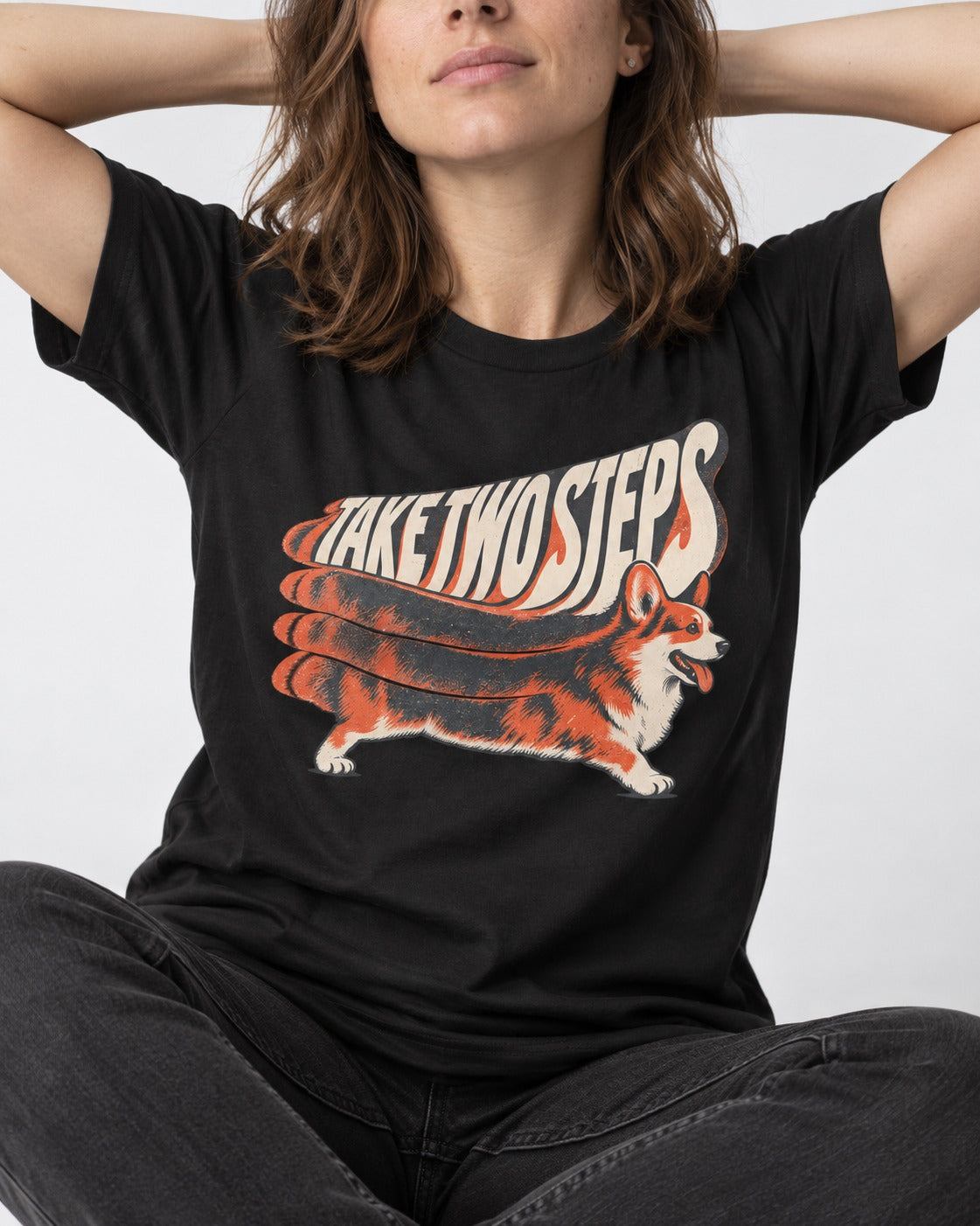 Corgi Take Two Steps Motion Trail Graphic T-Shirt in Black, worn by a seated model