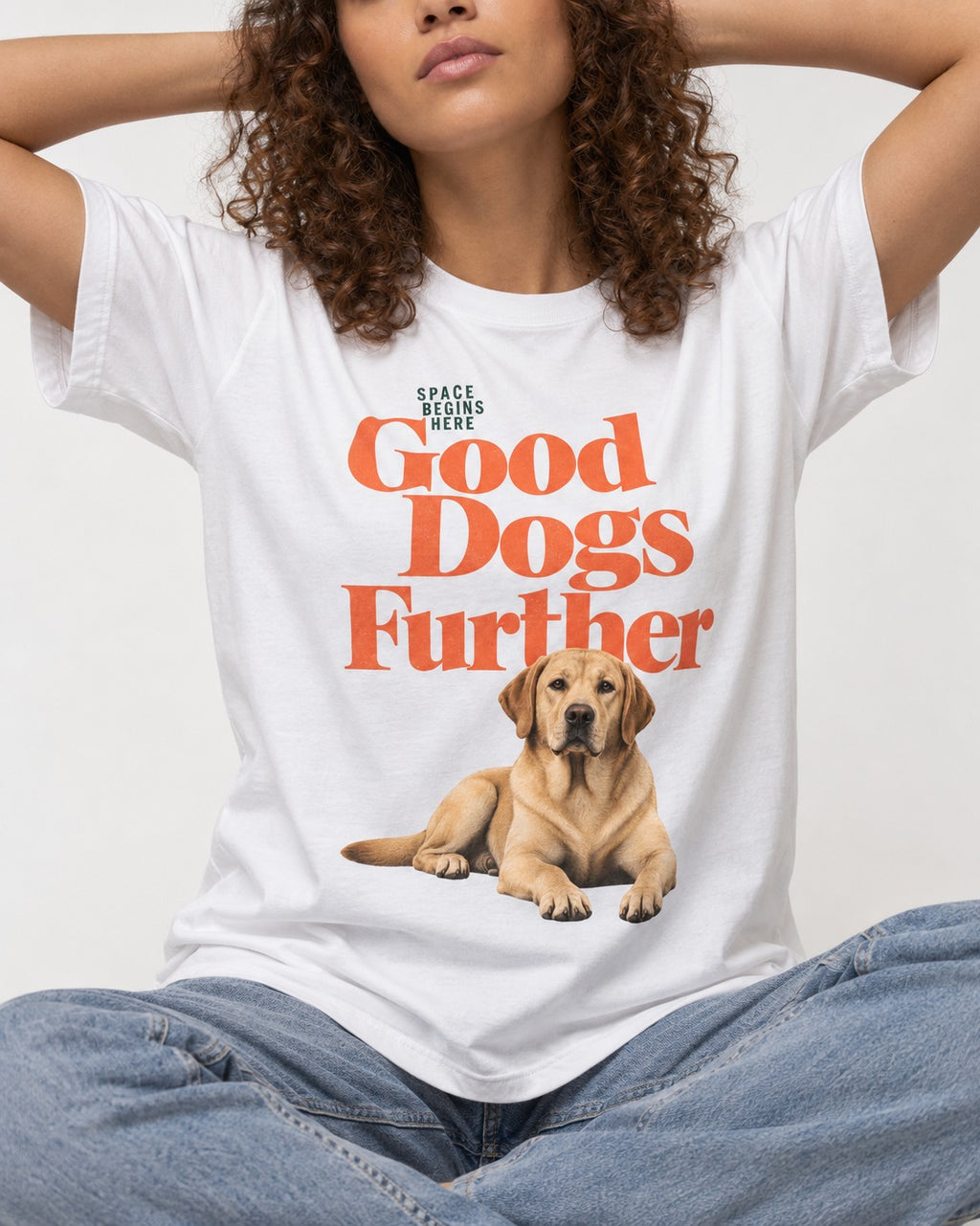 Good Labrador Retriever Goes Further T-Shirt in White, worn by a seated model