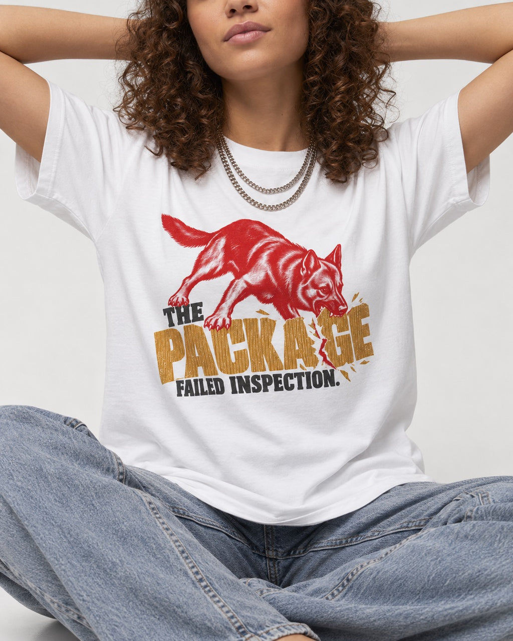 The Package Failed Inspection German Shepherd Dog T-Shirt in White, worn by a seated model