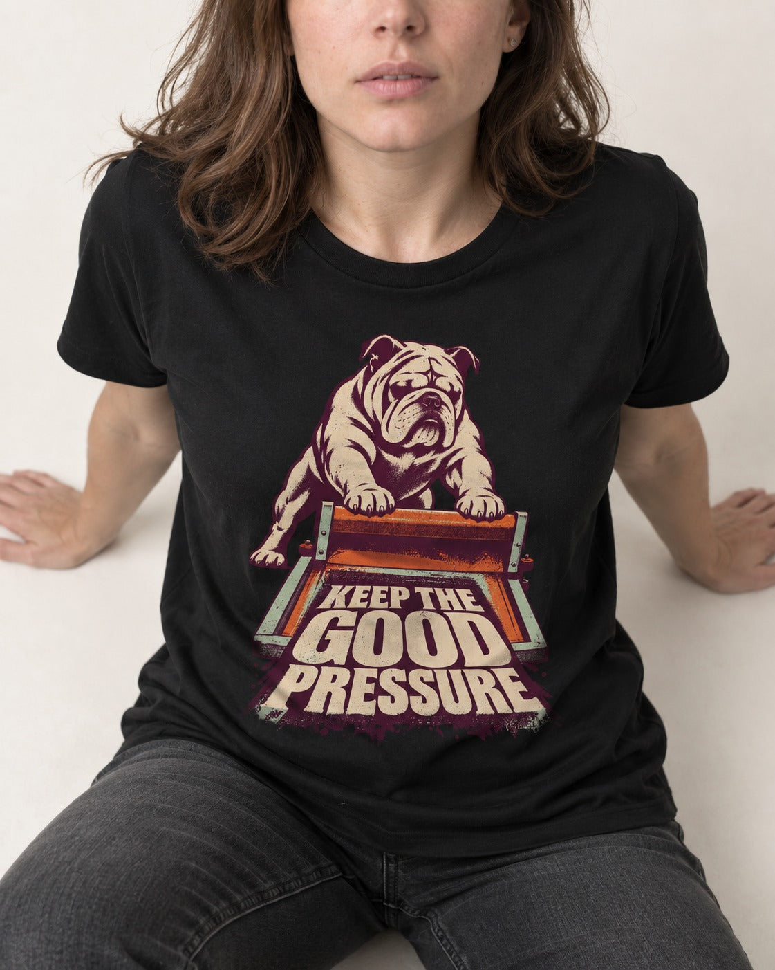 English Bulldog Keep the Good Pressure Printing Press Graphic T-Shirt in Black, worn by a seated model