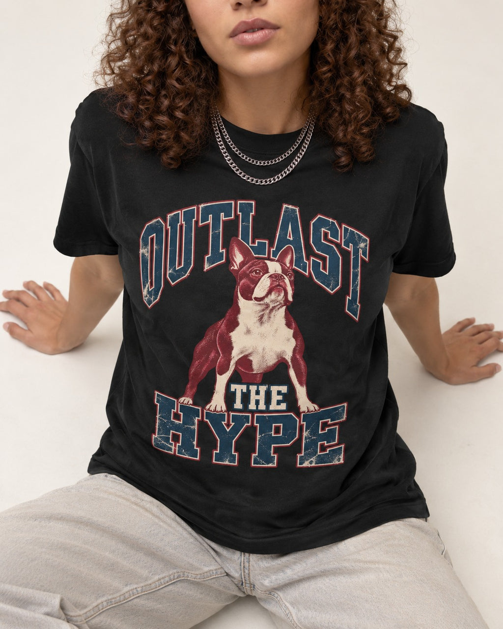 Boston Terrier Outlast The Hype Collegiate Graphic T-Shirt in Black, worn by a seated model