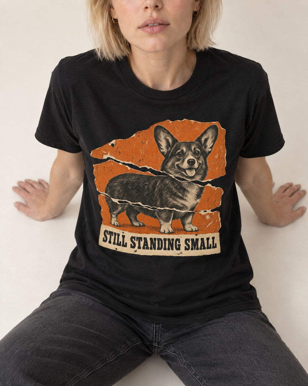 Corgi Still Standing Small Torn Poster T-Shirt in Black, worn by a seated model