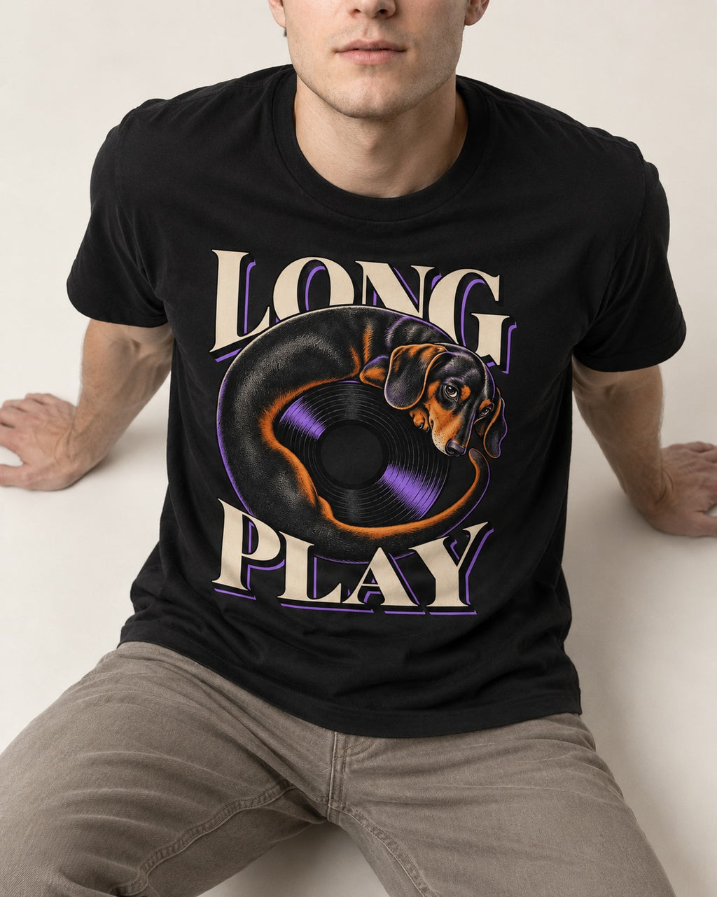 Dachshund Long Play Vinyl Record Graphic T-Shirt in Black, worn by a seated model