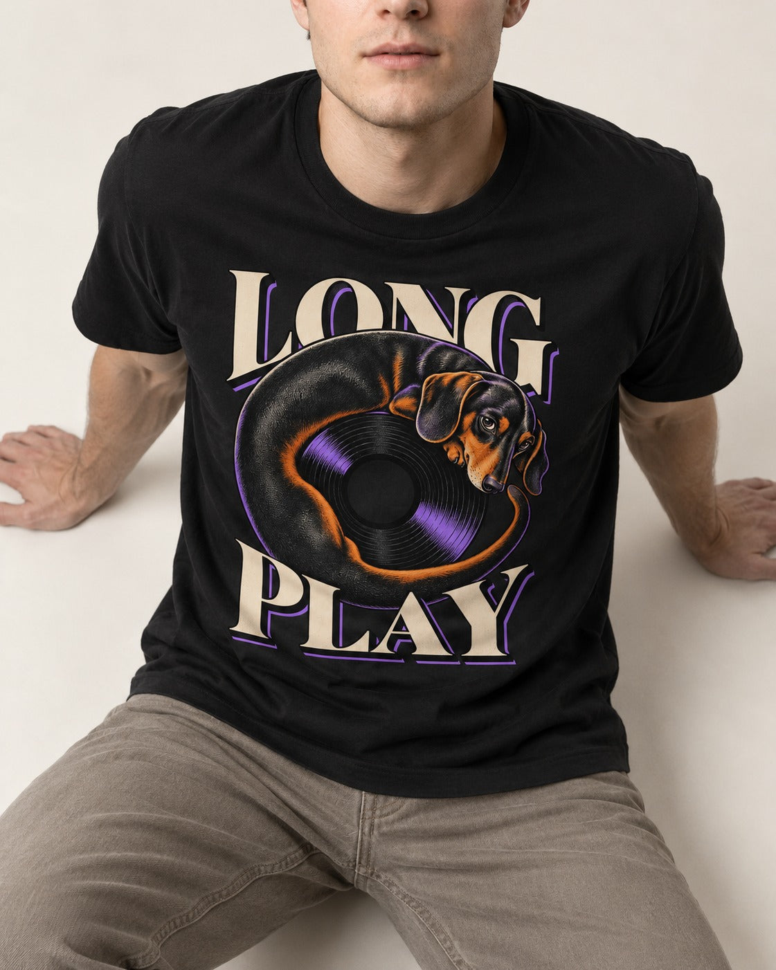 Dachshund Long Play Vinyl Record Graphic T-Shirt in Black, worn by a seated model