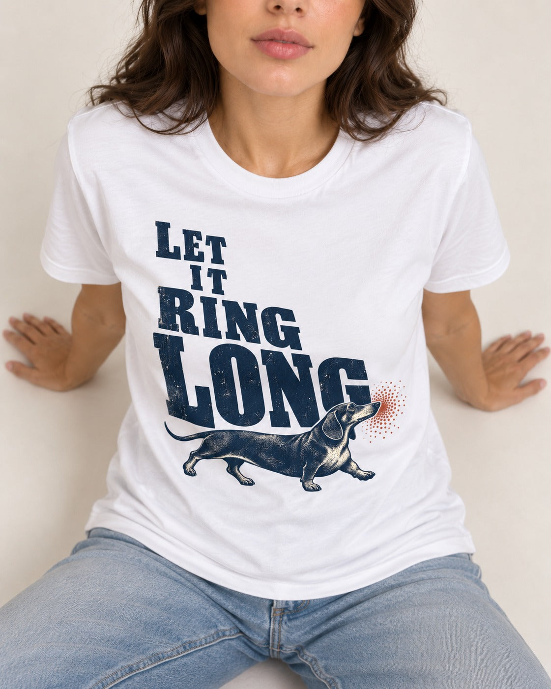 Let It Ring Long Dachshund T-Shirt in White, worn by a seated model