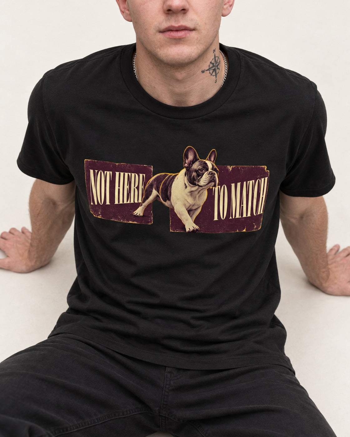 Frenchie Not Here to Watch Panels Graphic T-Shirt in Black, worn by a seated model