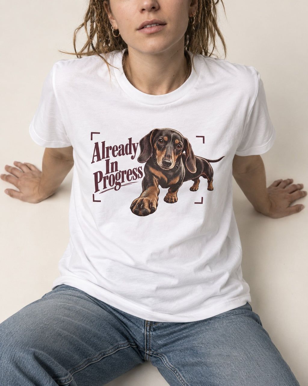 Dachshund Already in Progress T-Shirt in White, worn by a seated model