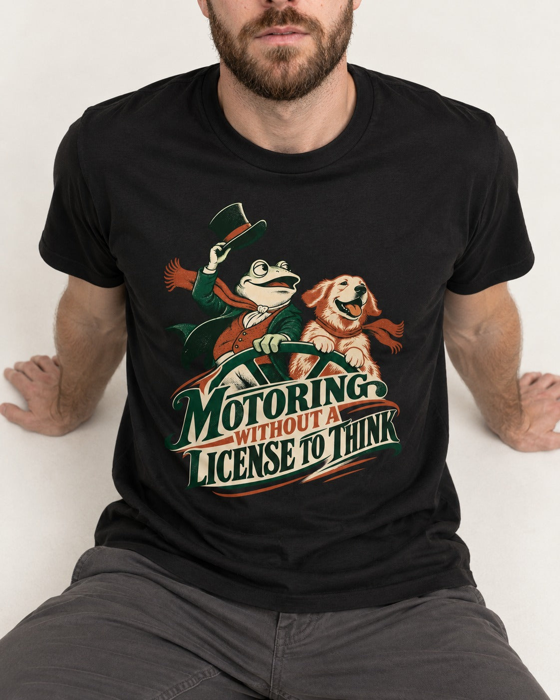 Golden Retriever Motoring Without a License to Think Driving Graphic T-Shirt in Black, worn by a seated model