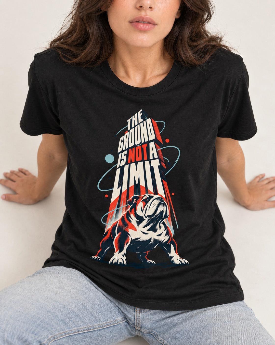 English Bulldog The Ground Is Not a Limit Orbital Graphic T-Shirt in Black, worn by a seated model