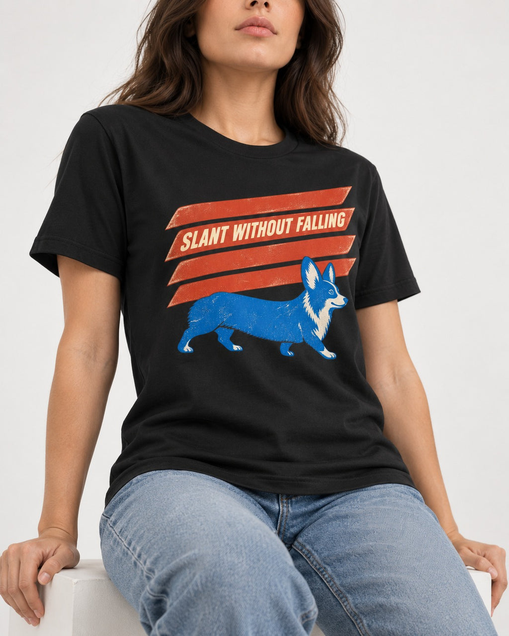 Corgi Slant Without Falling Speed Graphic T-Shirt in Black, worn by a seated model