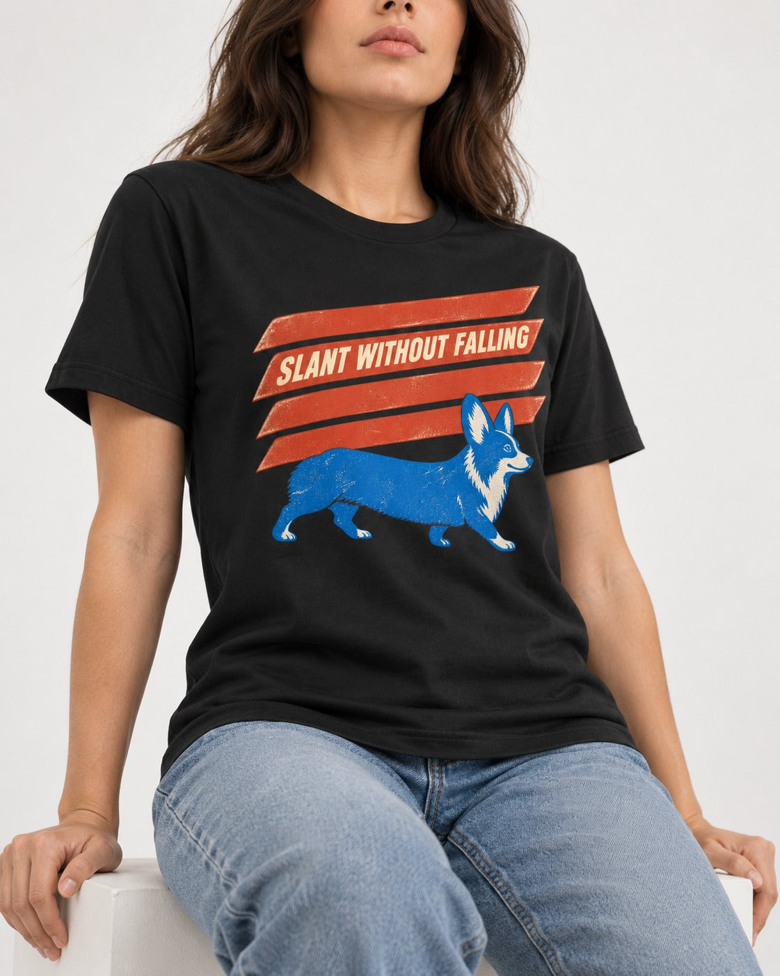 Corgi Slant Without Falling Speed Graphic T-Shirt in Black, worn by a seated model