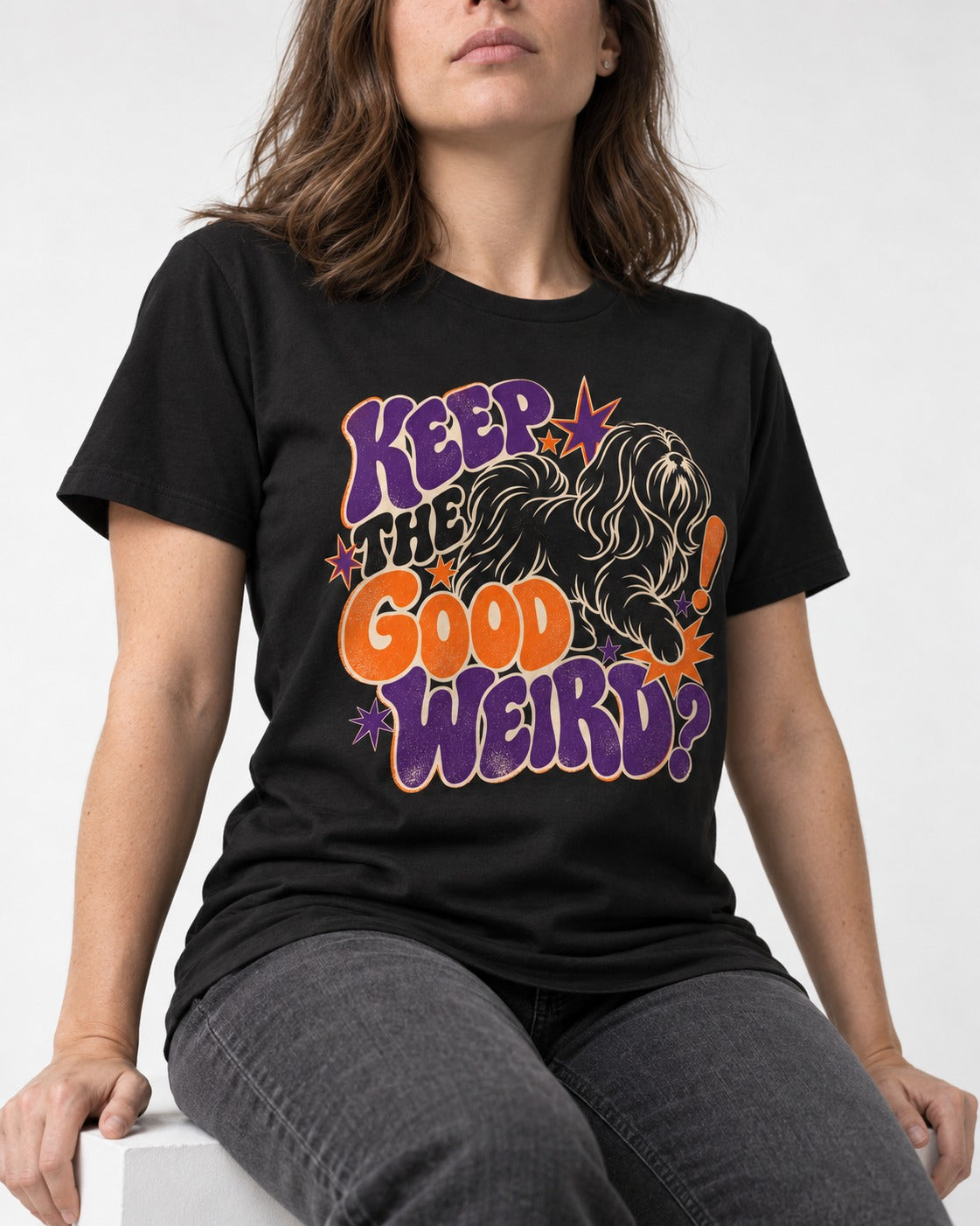 Shih Tzu Keep the Good Weird Retro Typography Graphic T-Shirt in Black, worn by a seated model