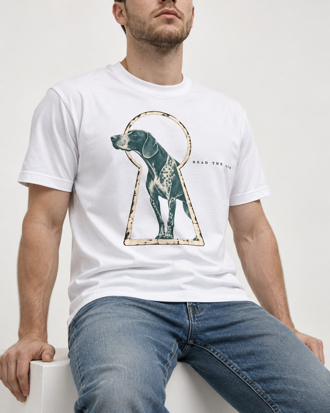 Read the Air German Shorthaired Pointer T-Shirt in White, worn by a seated model