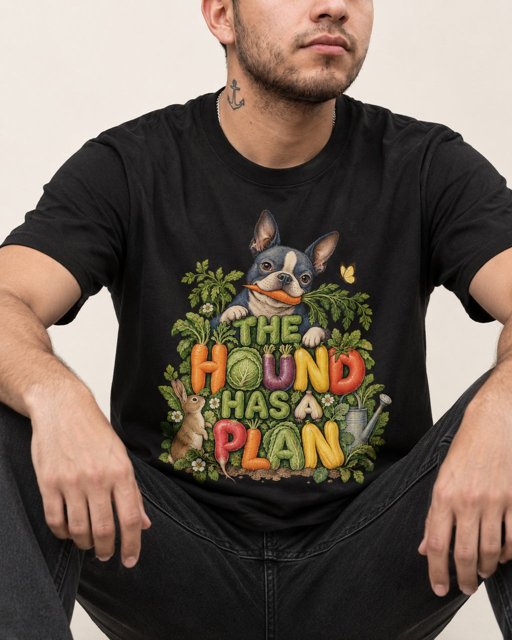 The Hound Has a Plan Boston Terrier T-Shirt in Black, worn by a seated model