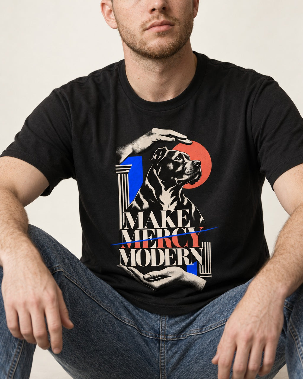 Pitbull Make Mercy Modern Protective Hands Graphic T-Shirt in Black, worn by a seated model
