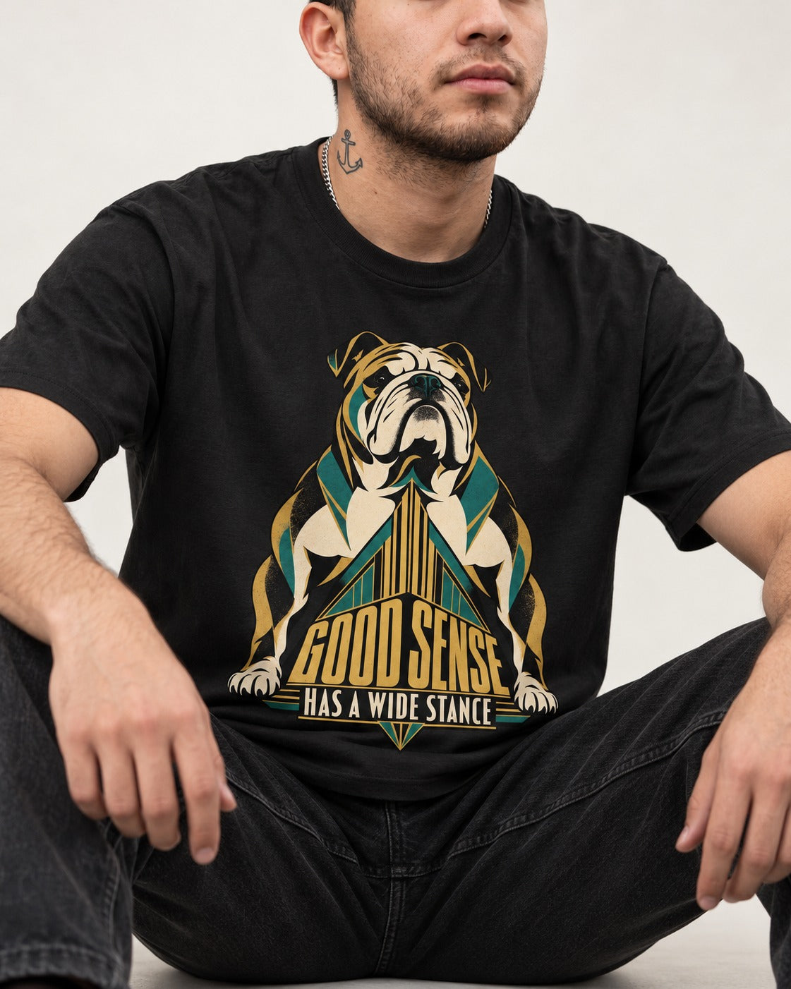 Good Sense Has a Wide Stance English Bulldog Graphic T-Shirt in Black, worn by a seated model