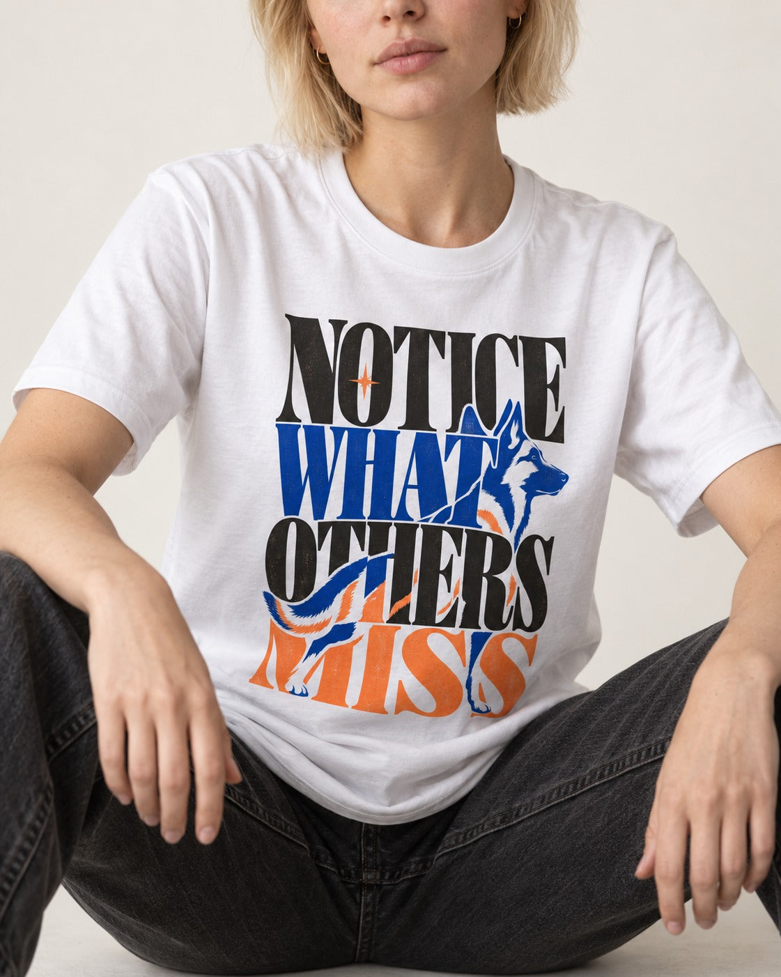 Notice What Others Miss German Shepherd Dog T-Shirt in White, worn by a seated model