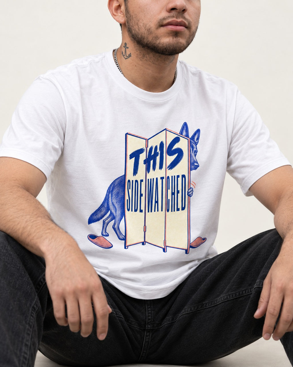 This Side Watched by German Shepherd Dog T-Shirt in White, worn by a seated model