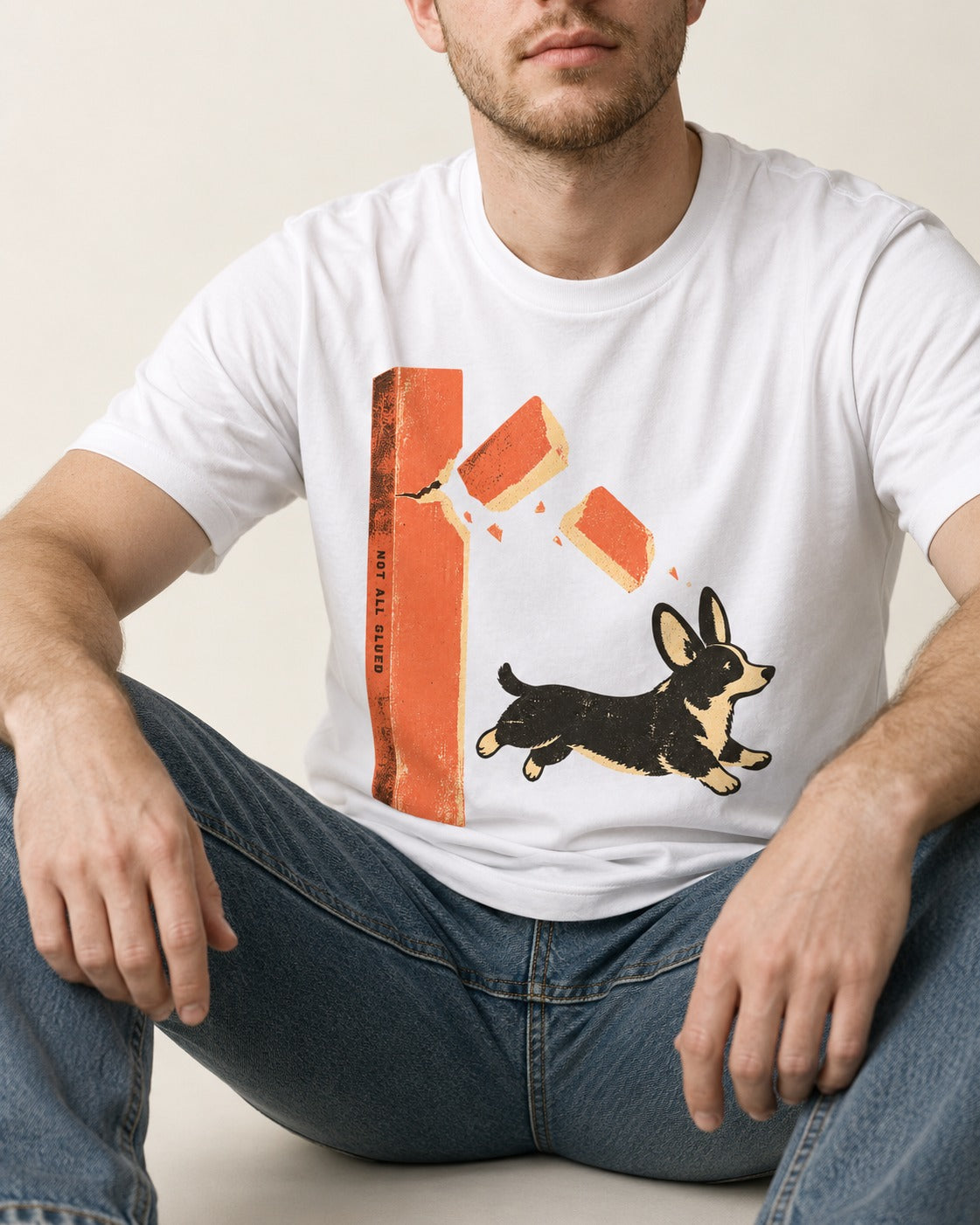 Not All Glued Corgi T-Shirt in White, worn by a seated model