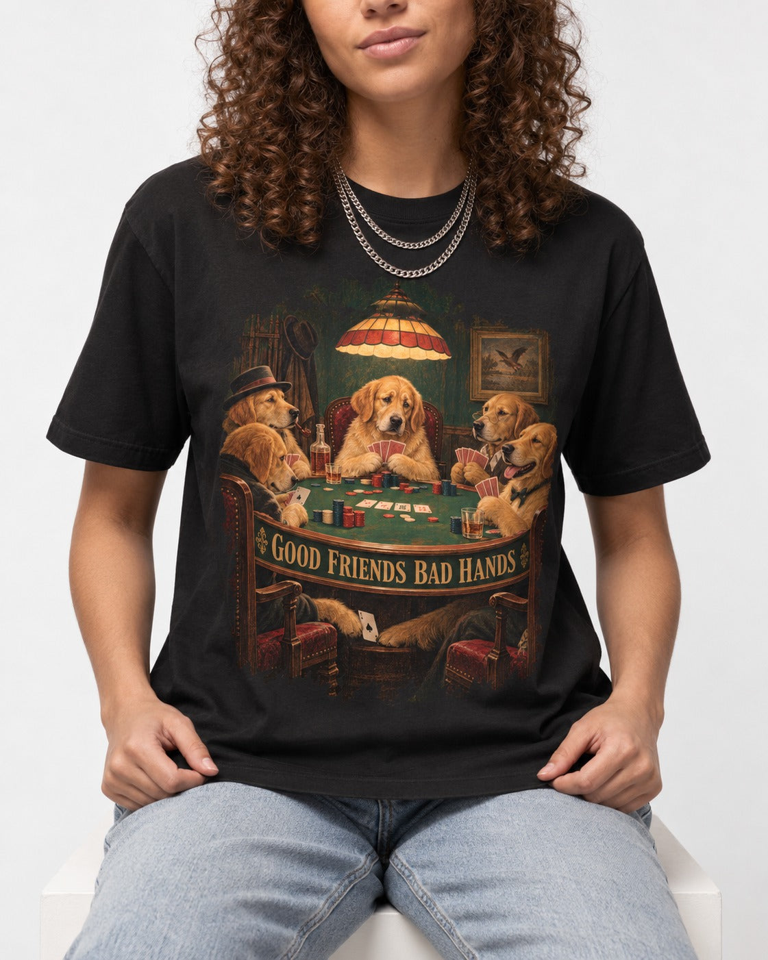 Good Friends Bad Hands Poker Golden Retriever Graphic T-Shirt in Black, worn by a seated model