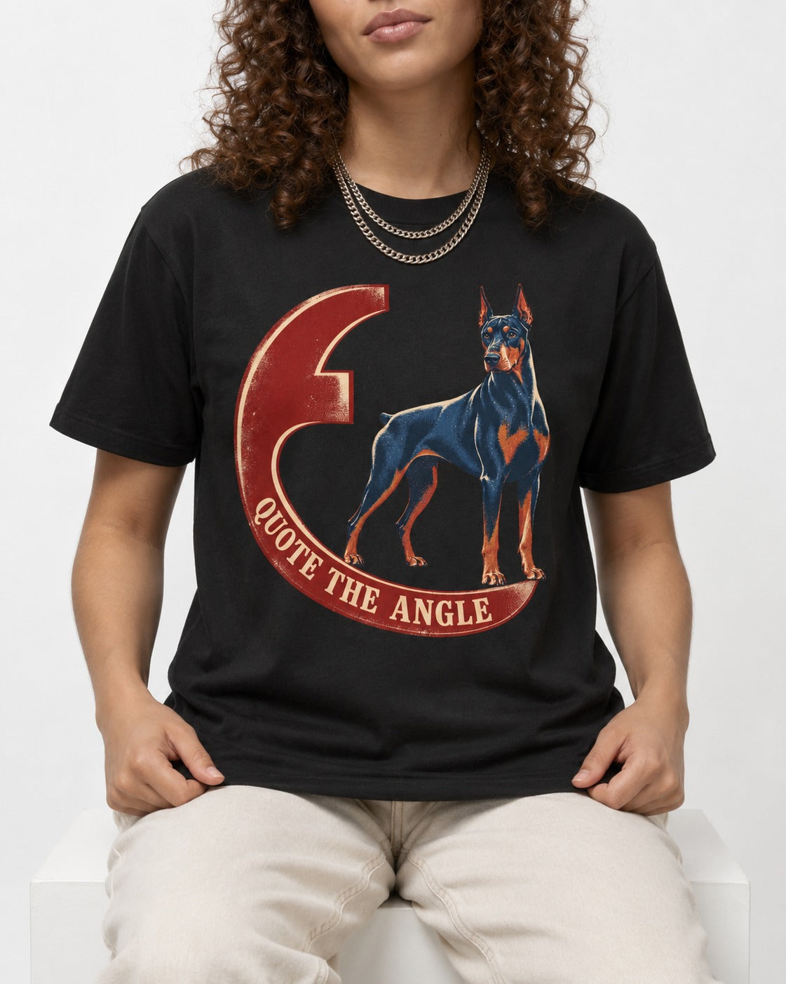 Doberman Quote the Angle Crescent Graphic T-Shirt in Black, worn by a seated model