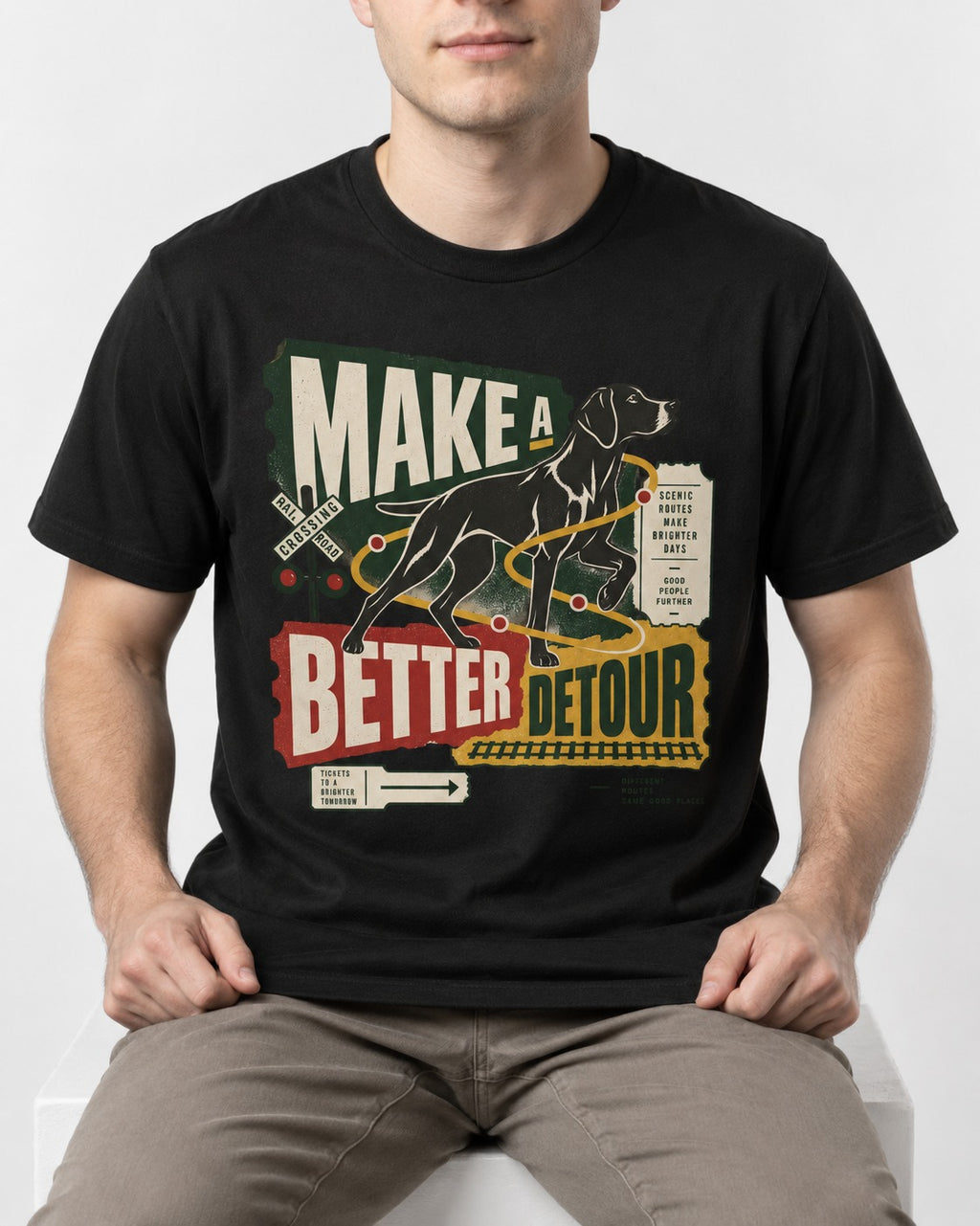 German Shorthaired Pointer Make a Better Detour Railroad Graphic T-Shirt in Black, worn by a seated model