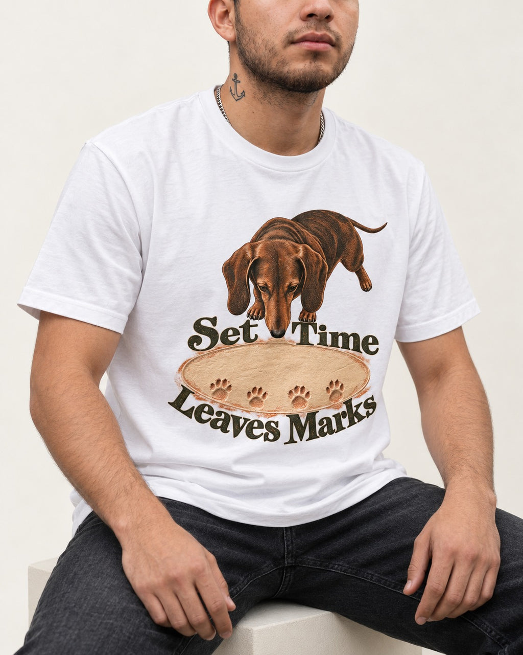 Dachshund Time Leaves Marks T-Shirt in White, worn by a seated model