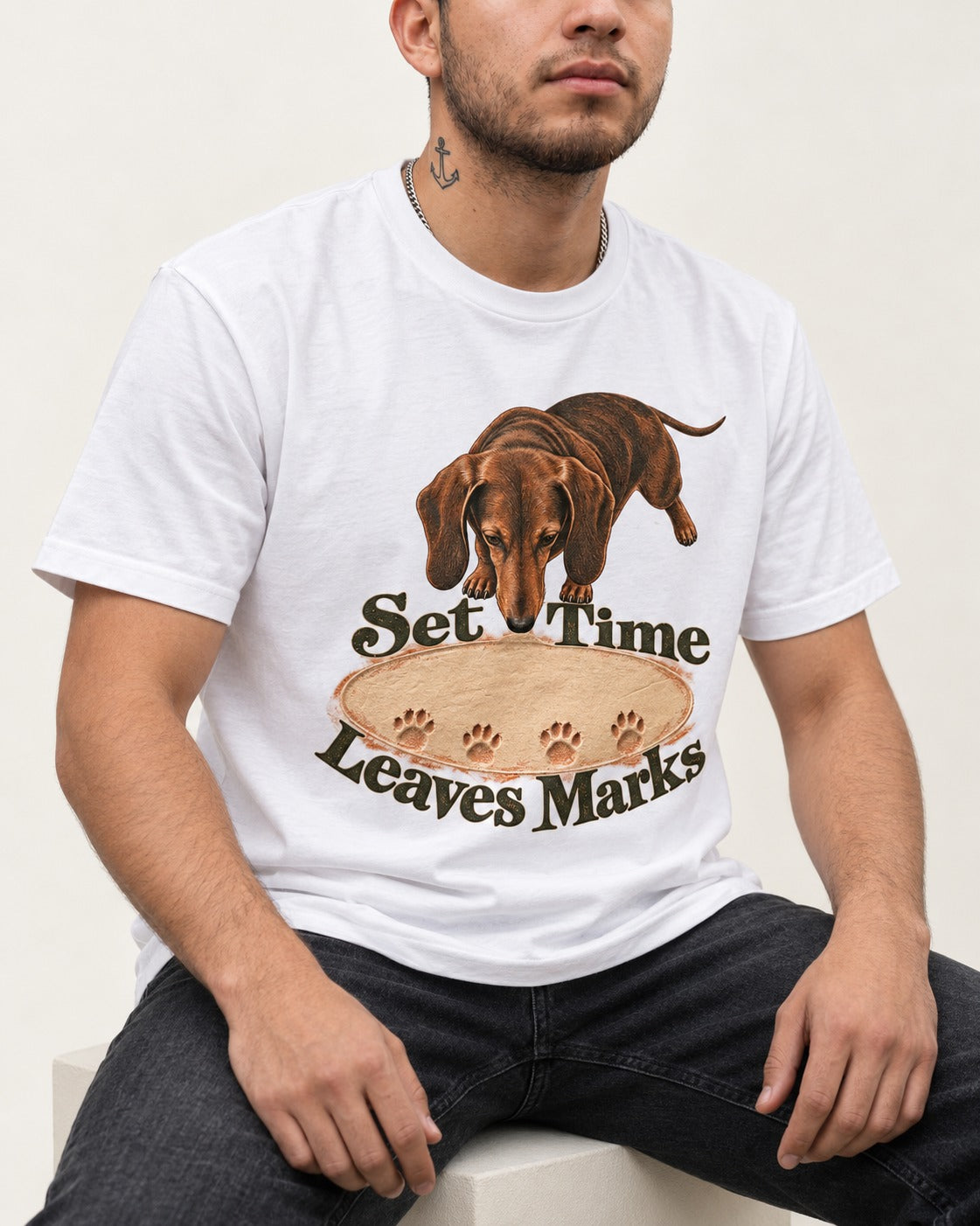 Dachshund Time Leaves Marks T-Shirt in White, worn by a seated model
