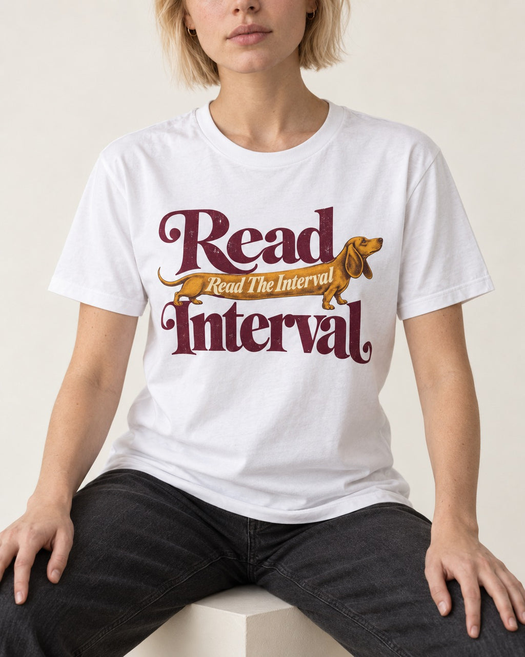 Read the Dachshund Interval T-Shirt in White, worn by a seated model
