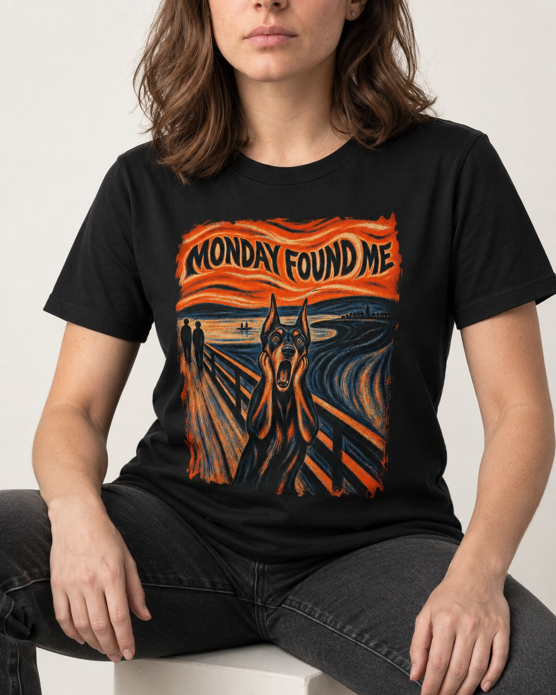 Doberman Monday Found Me Scream Graphic T-Shirt in Black, worn by a seated model