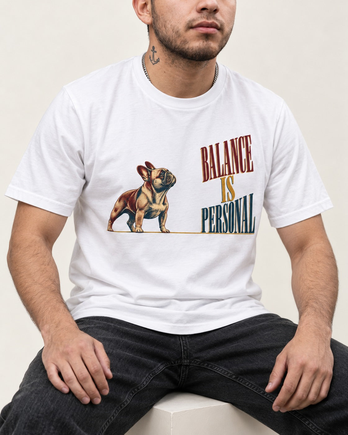 Frenchie Balance Is Personal T-Shirt in White, worn by a seated model