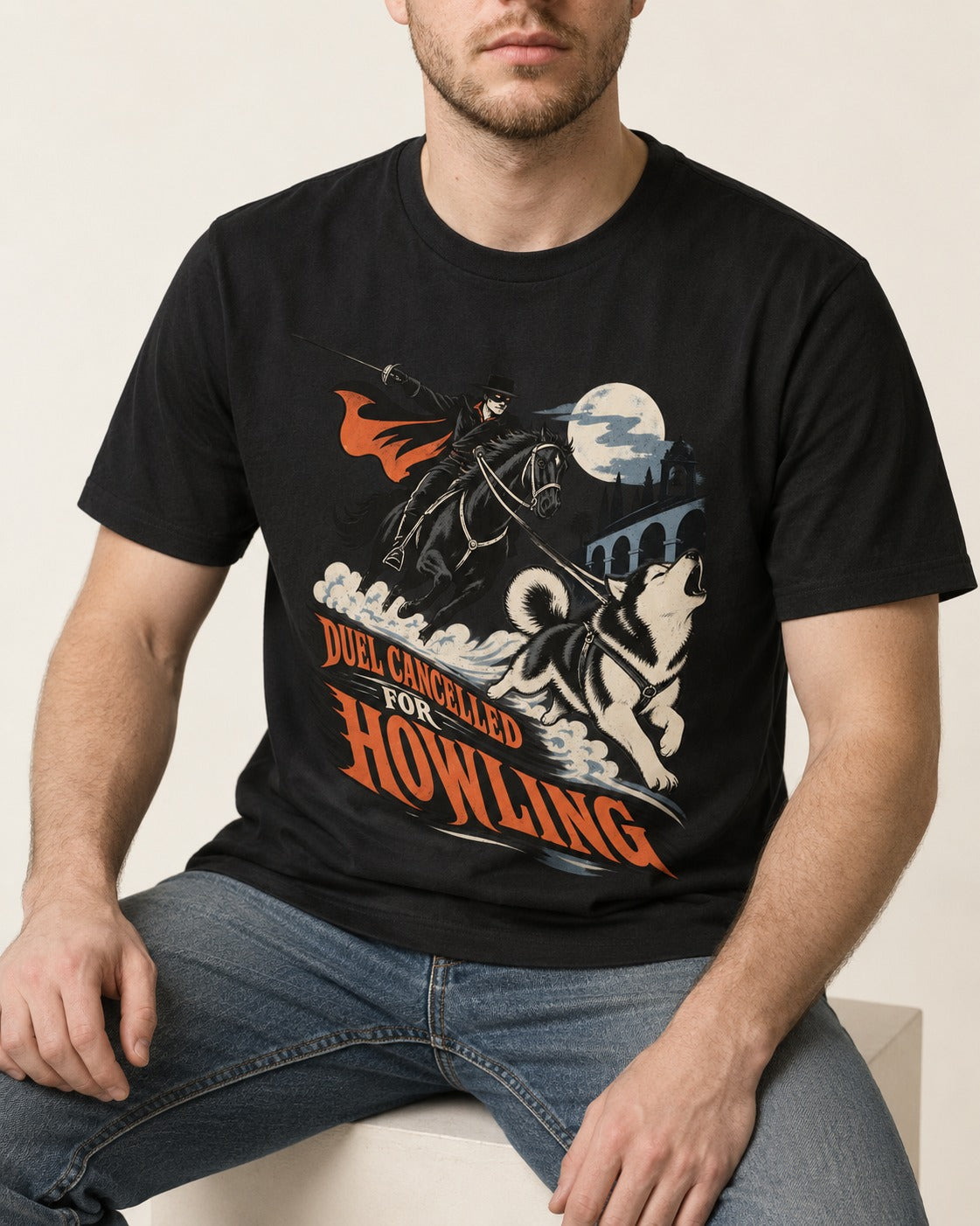 Husky Duel Cancelled for Howling Masked Rider Graphic T-Shirt in Black, worn by a seated model