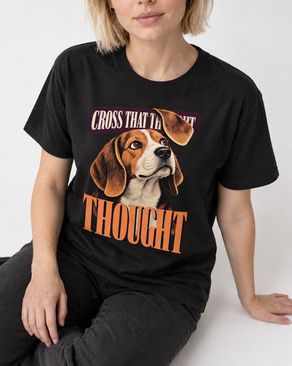Cross That Beagle Thought T-Shirt in Black, worn by a seated model