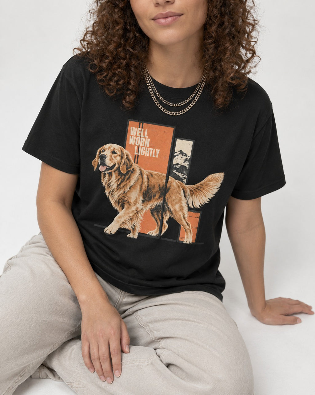 Golden Retriever Well Worn Lightly Mountain Graphic T-Shirt in Black, worn by a seated model