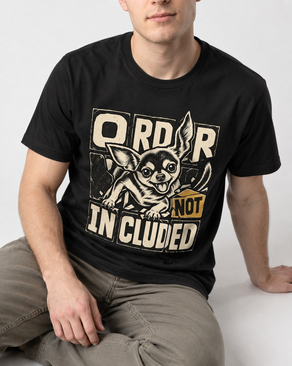 Chihuahua Order Not Included Broken Grid Graphic T-Shirt in Black, worn by a seated model