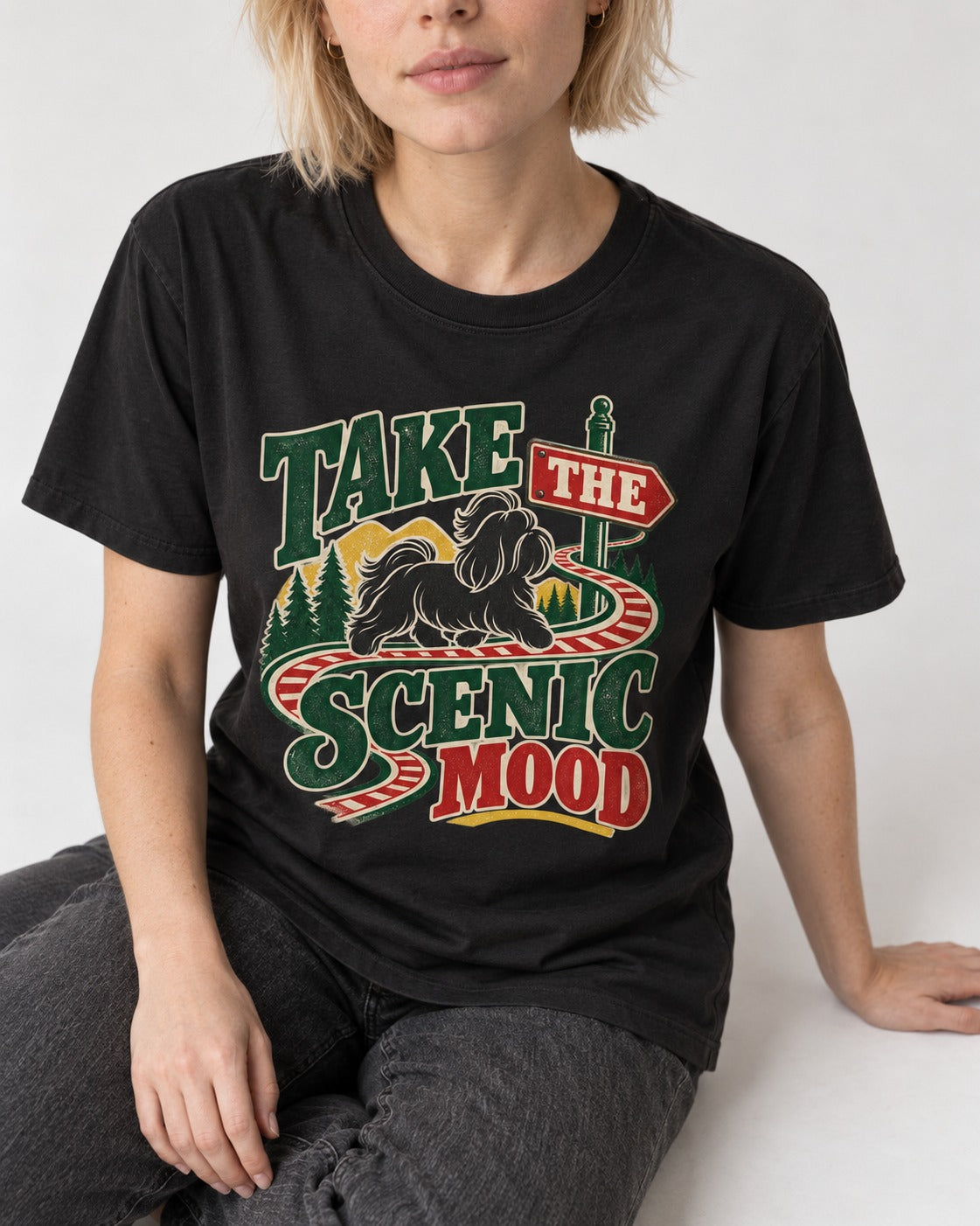 Shih Tzu Take the Scenic Mood Road Sign Graphic T-Shirt in Black, worn by a seated model