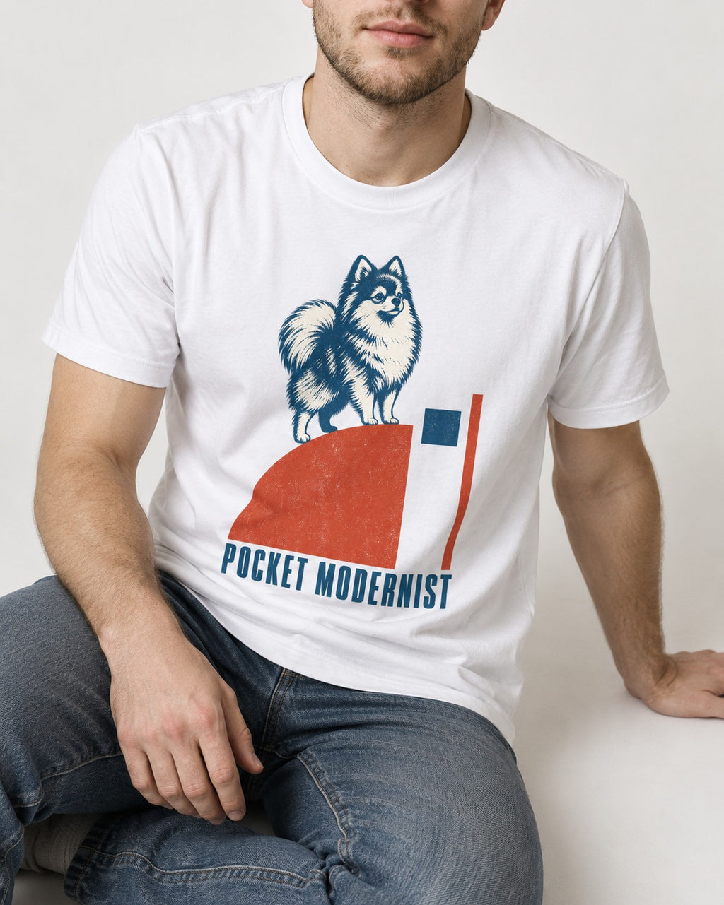 Pocket Modernist Pomeranian T-Shirt in White, worn by a seated model