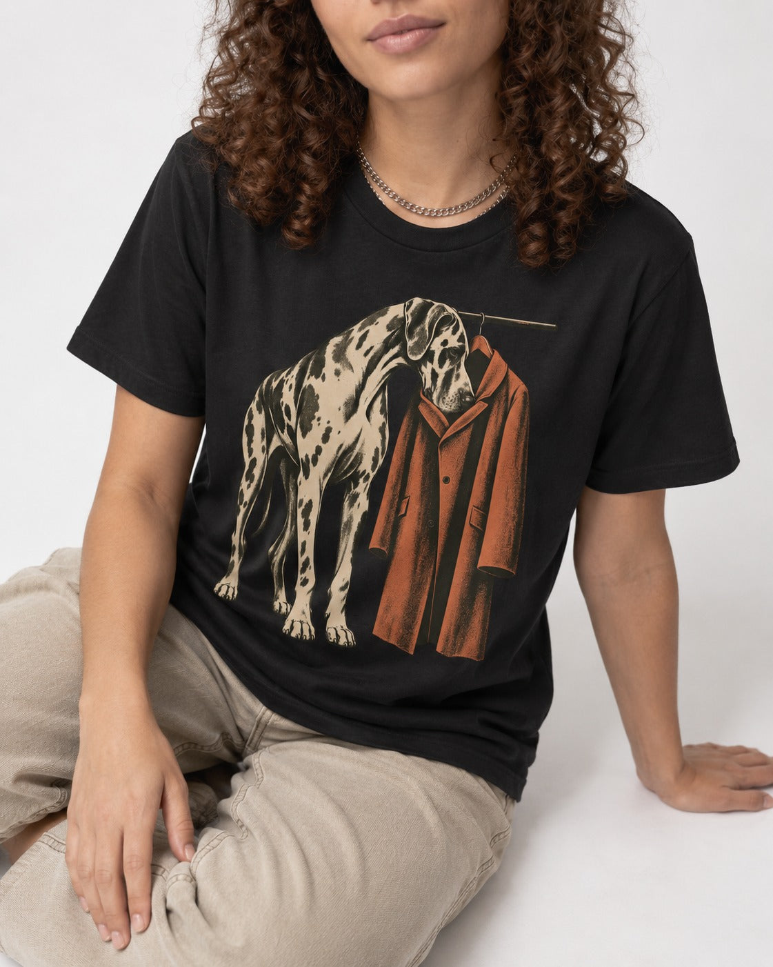 Great Dane Harlequin Coat Rack Overcoat Graphic T-Shirt in Black, worn by a seated model
