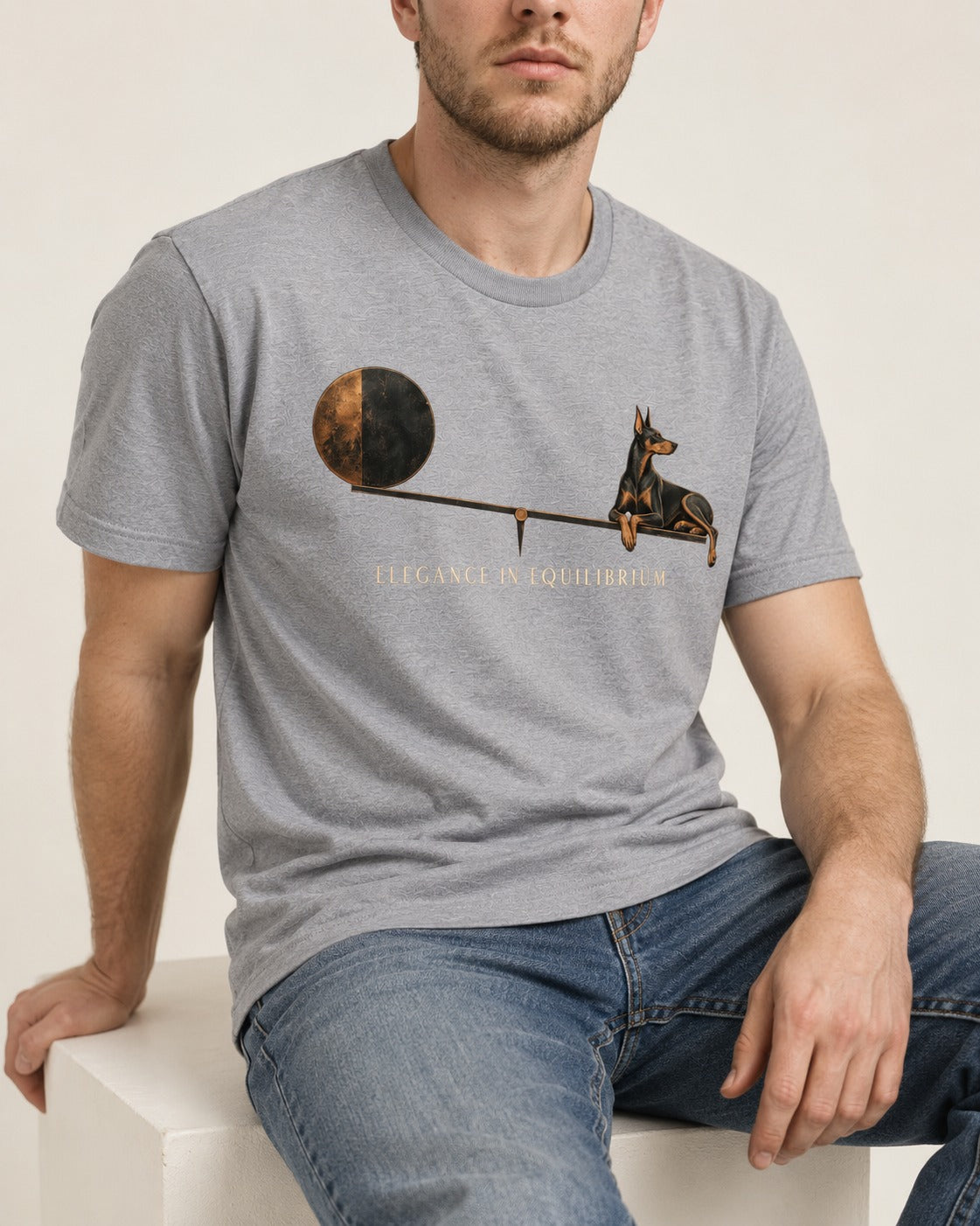 Doberman Elegance in Equilibrium Balance Graphic T-Shirt in Sport Grey, worn by a seated model