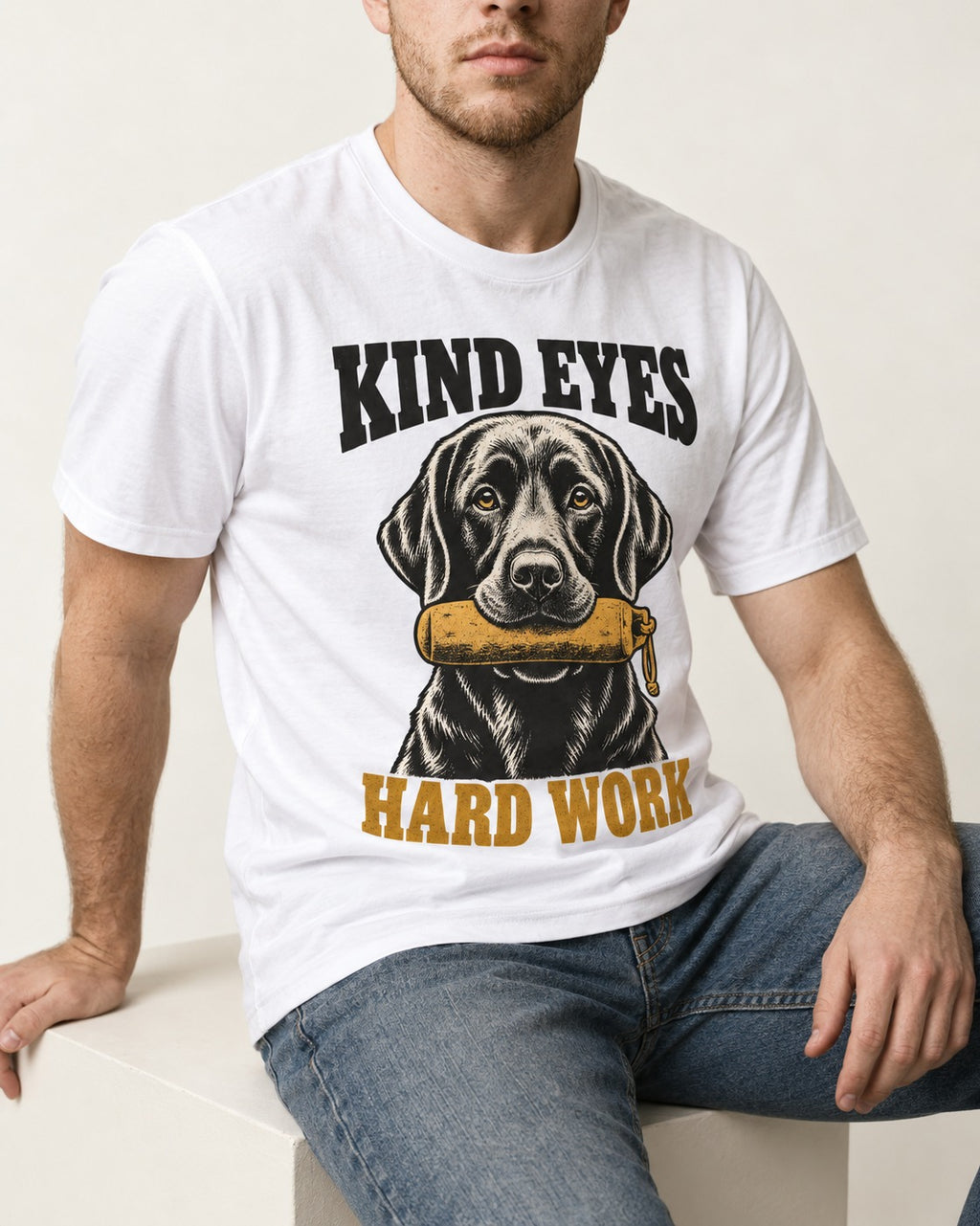 Kind Eyes Hard Work Labrador Retriever T-Shirt in White, worn by a seated model