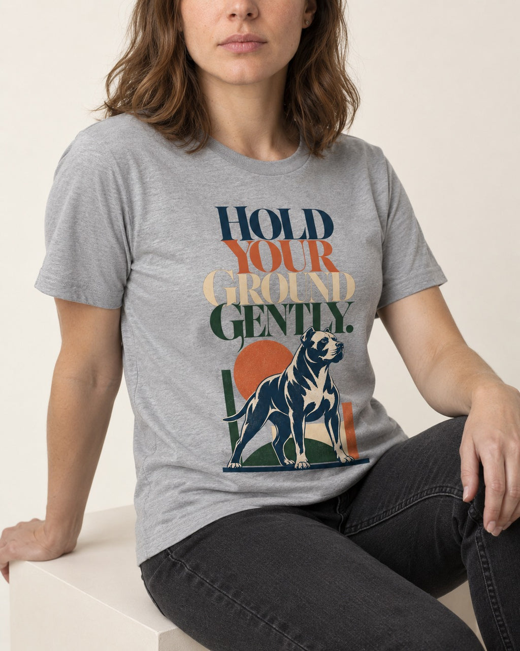 Pitbull Hold Your Ground Gently Standing Dog Graphic T-Shirt in Sport Grey, worn by a seated model