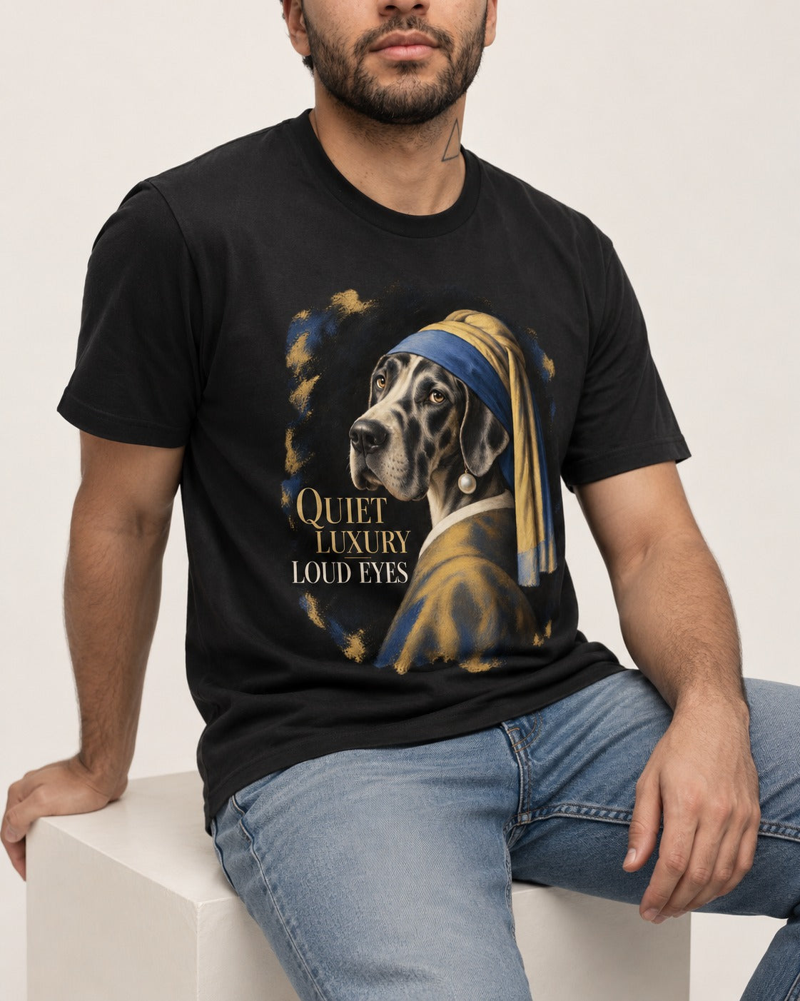 Great Dane Quiet Luxury Loud Eyes Pearl Portrait Graphic T-Shirt in Black, worn by a seated model